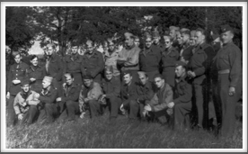 Unknown date, Oflag 64 group photo taken just outside of camp. (right view) Kneeling, l-r:  3rd, Tony Cipriani; 4th, Otto Amerell; 5th, Roy Chappell; 6th, Everette Anderson; 9th, Major Hugo Fielschmidt; Standing middle row l-r: 3rd, William Harlow; 4th, Nick Rahal; 6th, Billy Bingham; 7th, Lou Otterbein; 9th, Robert Henry, Jr.; far right, Col. Thomas Drake